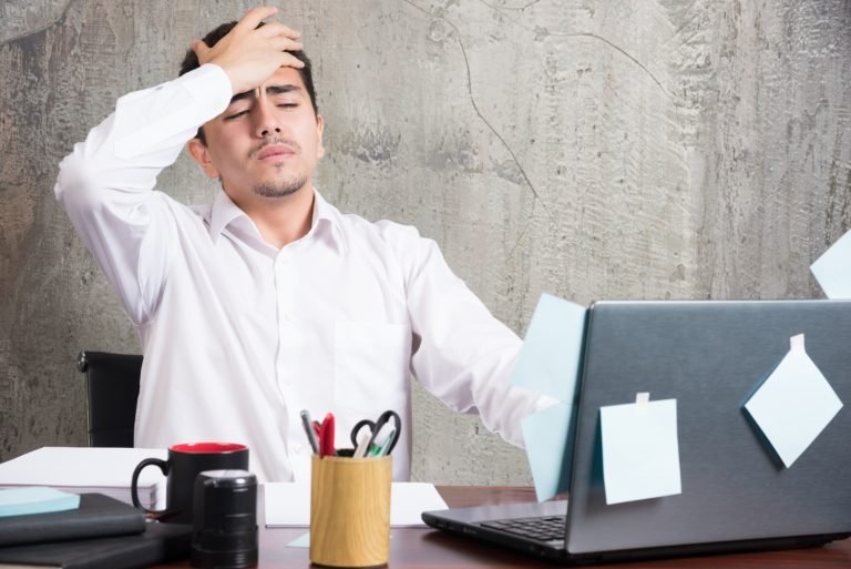businessman-having-headache-office-desk